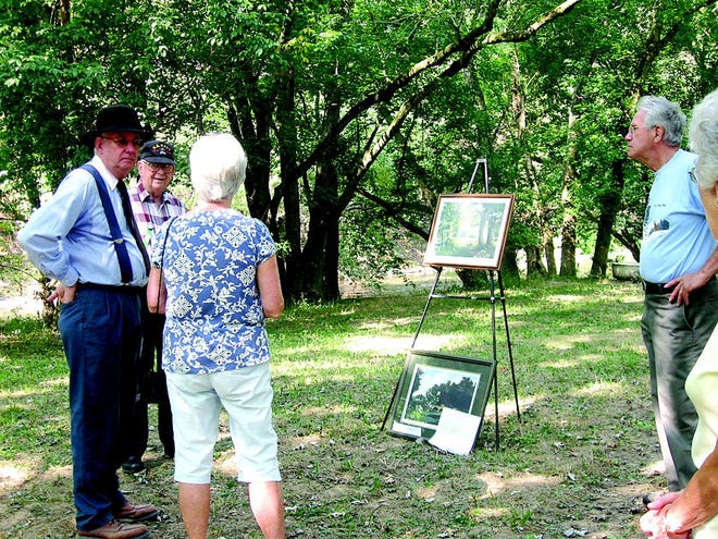 During a tour of Sandy Hollow, Jerry Harness showed visitors paintings of the area as it might have looked 100 years ago.