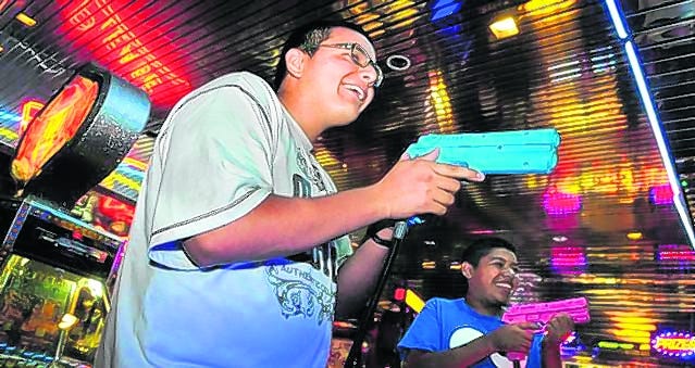 Manuel Perez and Francisco Lopez play a shooting game at Fun-N-Games 
arcade.STAFF PHOTO / DAN WAGNER