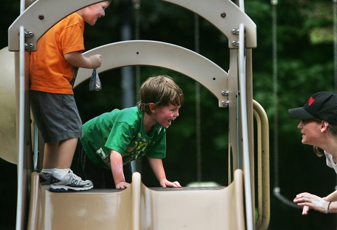 Kirsten Kuchinsky, right, of Bellingham tries to catch her son, Maddox, 3, center, as he plays hard to get. She is attempting to put sunscreen on his arms and face at Bellingham Town Common on Thursday as Liam Gallagher, 3, left, also of Bellingham, looks on.