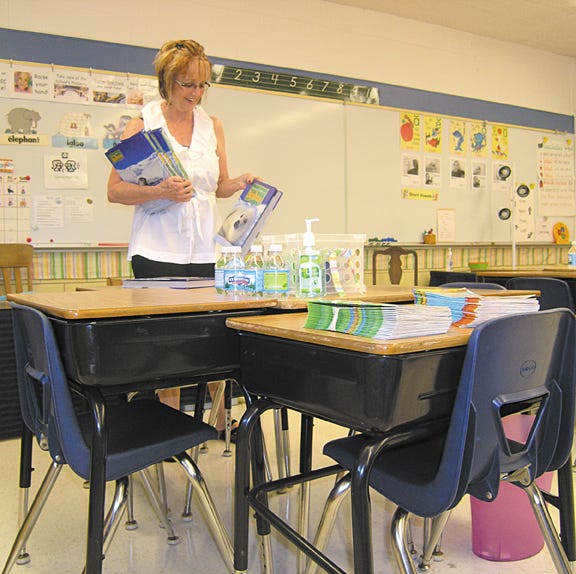 Kathy Sutter, a teacher at Central School, works on arranging her first grade classroom on Thursday. Students in District 429 will go to school for the first day Wednesday.