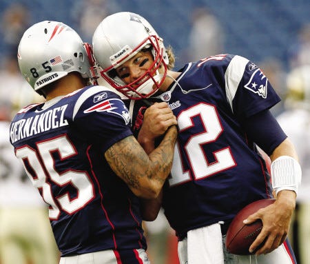 New England Patriots' Tom Brady (12) bumps helmets with rookie Aaron Hernandez before an NFL preseason football game against the New Orleans Saints in Foxborough, Mass., Thursday, Aug. 12, 2010. (AP Photo/Winslow Townson)