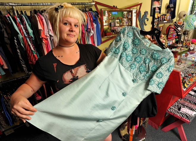Angela Grube, owner of 9th Life in Baltimore, Md., holds up a beaded silk-wool cocktail dress from the early 1960s. AMC' s hit drama "Mad Men" has captured fans not only for its Emmy-winning writing and acting, but also for its fashion. (Amy Davis/Baltimore Sun/MCT)