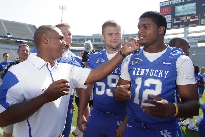 Kentucky head football coach Joker Phillips, left, checks the smoothness of quarterback Morgan Newton’s shave before the team photo was taken. Phillips is one of 12 black head football coaches at FBS schools, triple the number of two years ago.