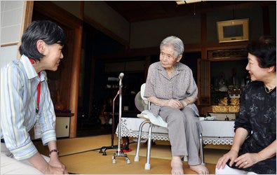 A Kobe city official, left, visited Mitsue Watase, 100, at her home last week as Japanese officials started a survey on the whereabouts of centenarians.