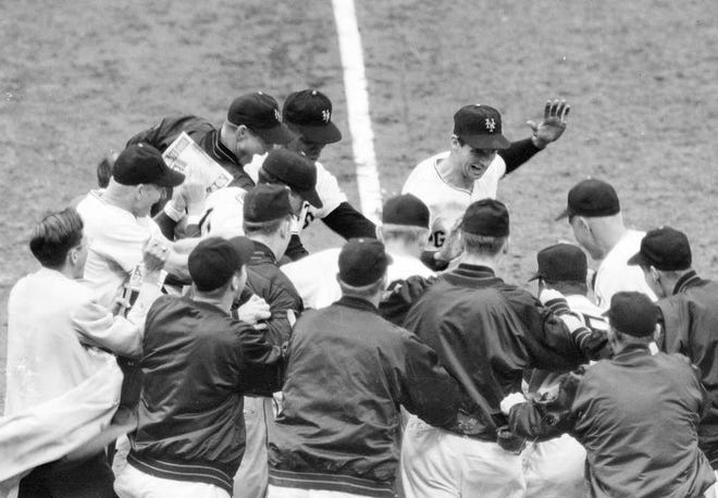 The New York Giants mobbed Bobby Thomson, center rear with his hand raised, after his ninth-inning home run against the Brooklyn Dodgers sent the Giants to the 1951 World Series. Thomson died Monday.