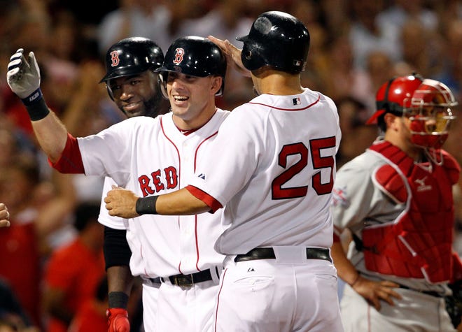 Ryan Kalish (center) celebrates his grand slam with David Ortiz (left) and Mike Lowell (25) as Angels catcher Bobby Wilson stands at right during the fourth inning of last night's Red Sox win at Fenway Park.