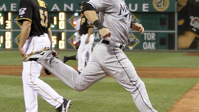 Florida Marlins' Logan Morrison, right, scores past Pittsburgh Pirates starting pitcher Zach Duke on a sacrifice fly by Dan Uggla in the Marlins' four-run fifth inning in a baseball game in Pittsburgh, Tuesday, Aug. 17, 2010. (AP Photo/Keith Srakocic)