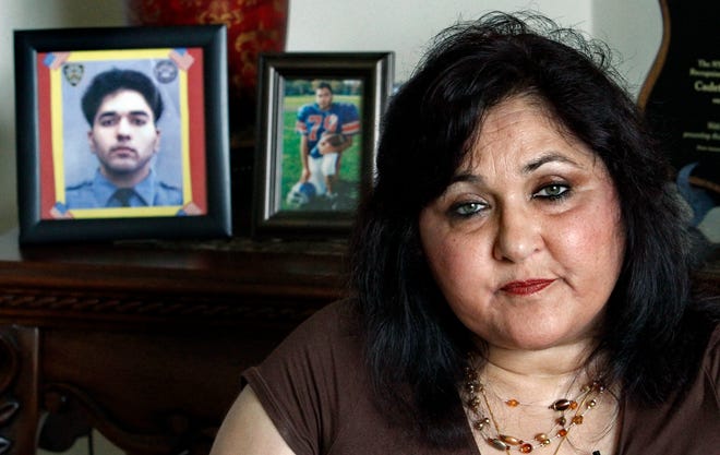 In this Tuesday, Aug. 17, 2010 photo, seated next to portraits of her son Mohammad Salman Hamdani, who was 23 when he died attempting to save lives at the World Trade Center on Sept. 11, 2001, Talat Hamdani sits during an interview in New York.