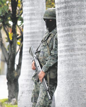 A masked soldier guards a street near Guadalajara, Mexico, where drug cartel 
leader Ignacio Coronel Villareal was killed last month.
AP PHOTO / CLAUDIO CRUZ