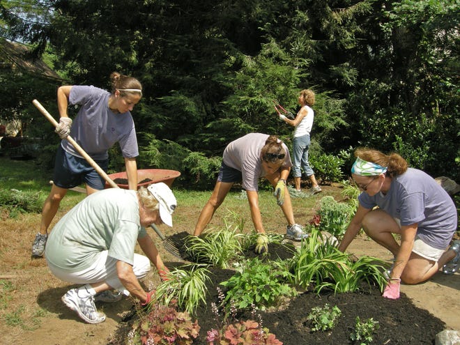 Volunteers put the finishing touches on one of the flowerbeds.