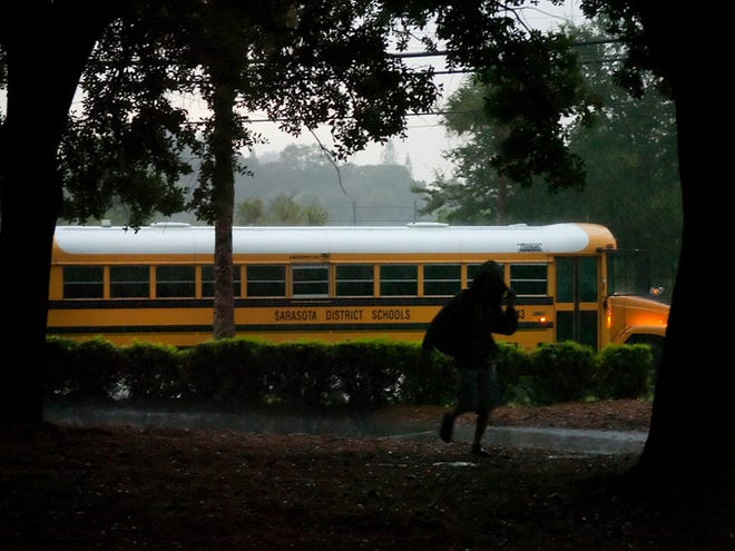 A student runs though the rain to class at Booker High School on Monday. Sarasota County students returned to their new school year on Monday.