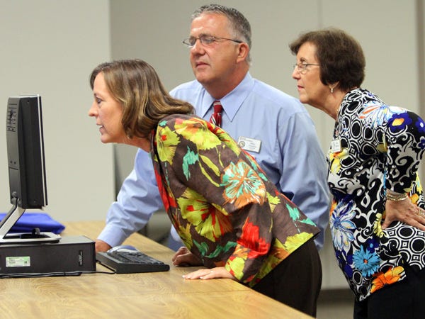 Judge Sarah Ritterhoff Williams, County Commissioner Mike Amsden and Supervisor of Elections Dee Brown, left to right, scrutinize primary election results as they come in at the Marion County Supervisor of Elections Office in Ocala.