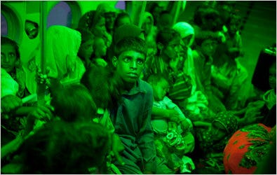 Some of those stranded by floodwaters in southeastern Pakistan, mostly women and children, were taken by helicopters on Tuesday to safer ground in Shadadkot. The cabin is lighted with green light to accommodate the crew’s night-vision goggles.