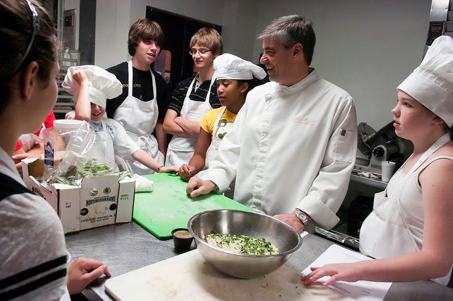 Chef Paul Mattison, second from right, reacts as 12-year-old Harrison Gammaro's hat slips down during Chef Camp at Mattison's 41 in Sarasota on Thursday, Aug. 19, 2010. Also with them at the table are Scott Stevenson, 14, third from left, Nick Cropper, 13, Daria Curley, 11, and Brooke Rohan, 12, right.