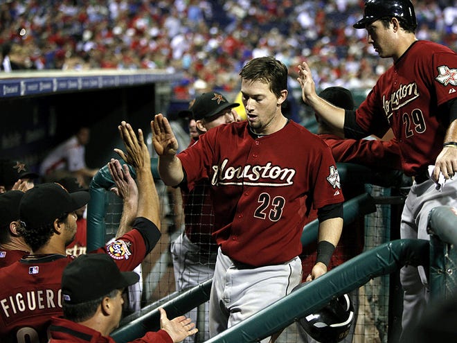 Houston Astros' Chris Johnson, center and Brett Wallace, right, are congratulated as they return to the dugout in the 16th inning of a baseball game in Philadelphia, Wednesday, Aug. 25, 2010. Houston won 4-2 in 16 innings. (AP Photo/Matt Rourke)