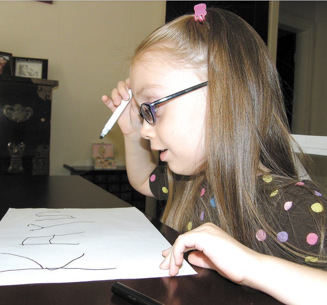 Five-year-old Kaytlyn Floyd writes her name Tuesday in her Waynesboro home. Kaytlyn has won second place in the preschool/kindergarten category in the APH InSights 2010 international art competition for visually impaired or blind artists for her crayon and marker drawing ‘Singing in the Rain.’