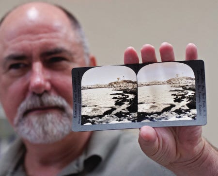 Ogunquit Museum of American Art Executive Director Ron Cusan displays a vintage postcard of Nubble Lighthouse in York.