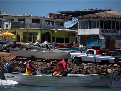 In this photo taken July 14, 2010, fishermen arrive to shore in the fishermen village of Popotla, some 15 miles south from the U.S.-Mexico border, Mexico. Gambling their lives, illegal immigrants are increasingly looking to the ocean as they consider crossing over land even more arduous and more likely to end by getting caught. U.S. agents have arrested 736 suspected illegal immigrants on Southern California shores and seas since October. (Guillermo Arias/ The Associated Press)