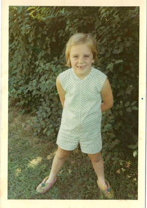 An elementary-age Maureen Mulvey shows her missing teeth for the camera.