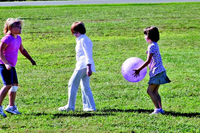 Jessi Wainman, Melaina Blunt and April Rogers play during recess in the Living Light Tabernacle's yard on Thursday.