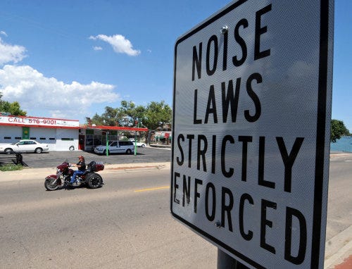 Signs posted along Sixth Avenue warn passers-by that noise laws are in effect.