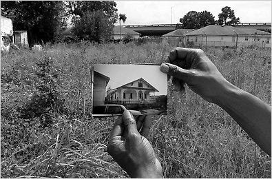 Michael Dupont, 59, holding a photo of his old house.