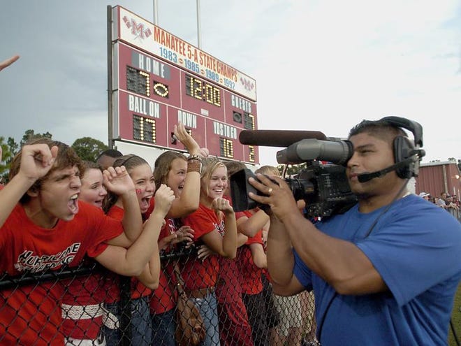 Fans go wild as ESPN cameraman Dondi Sanchez pans the line during the 
matchup of the Manatee Hurricanes against Tampa Plant in Bradenton Friday evening. The fall classic game was aired nationally on ESPN.