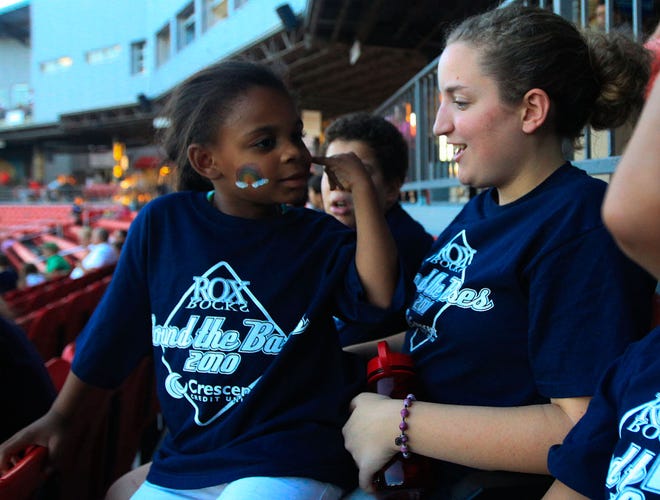 Karen Oliver, 5, of Brockton, talks about her face paint with Crescent Credit Union employee Emily Harriman during the Crescent Credit Union Round the Bases Reunion at Campanelli Stadium in Brockton.