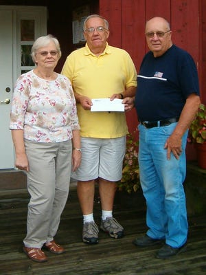 Henry County Board member Jim King (center) accepts a donation from Marilyn and Wilbur Nelson for the Henry County Courthouse Clock Tower.