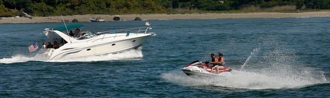 People on a big speedboat and a personal watercraft enjoy the water off of Nut Island in Quincy on Sunday.
