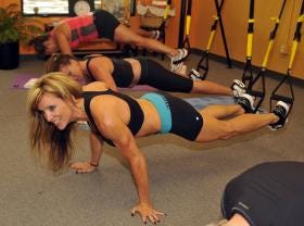 Fitness instructor Jodie Luther-Kofod leads a TRX class in a set of push-ups at Melt BodyMind Studio.