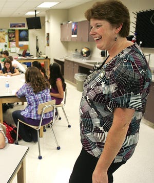 Annie Sullivan Middle School sixth-grade teacher Carol Allen shows how impressed she is with two of her students' speedy finish to the class's first assignment of the day during the opening day of school on Wednesday.