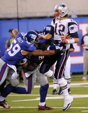 New England Patriots' Tom Brady, right, is hit by New York Giants' Michael Boley and Keith Bulluck during the first quarter of an NFL preseason football game at New Meadowlands Stadium in East Rutherford, N.J., Thursday, Sept. 2, 2010. (AP Photo/Bill Kostroun)
