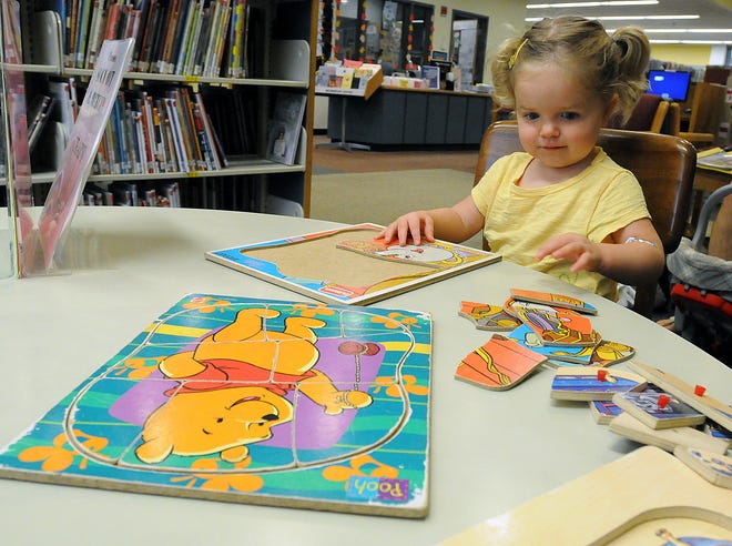 Naylanai Woodard, 2, avoided a rainy day and worked on some puzzles at the Milford Town Library on Friday.