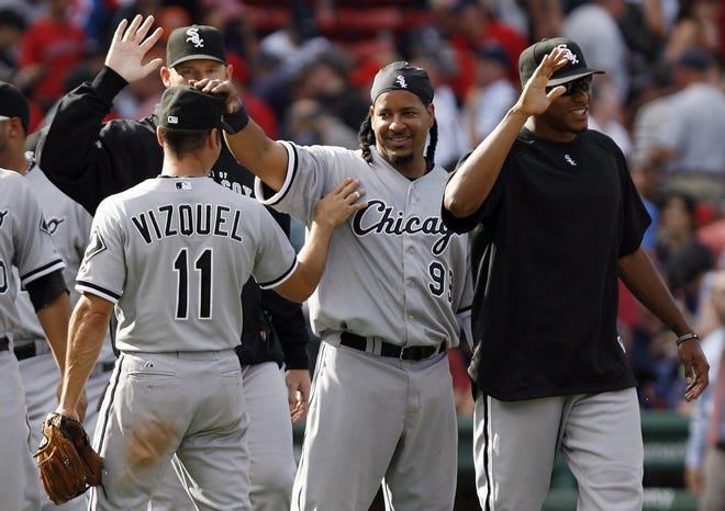 Chicago White Sox players, including, Omar Vizquel (11) and Manny Ramirez (99), congratulate each other after their 3-1 win over the Boston Red Sox in the first MLB baseball game in a day-night double header, Saturday, Sept. 4, 2010, at Fenway Park in Boston. (AP Photo/Mary Schwalm)