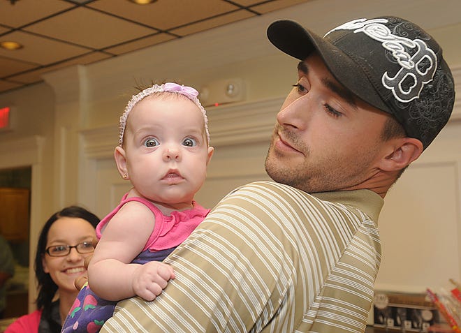 Staff Sgt. Jacob Boulay meets his niece, 4-month-old Alivia Howland,for the first time as Victoria Bartol - Alivia's mother and Boulay's sister - looks on.
