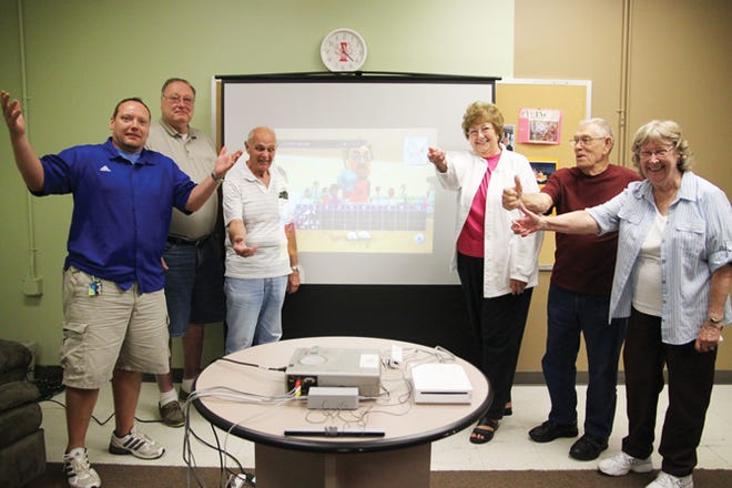 Wii bowling is serious business for Lowell Knap of Victor, John Vanderwalle of Farmington, Marilyn Knapp of Victor, Walter Smith and Fran Vanderwalle of Farmington. Victor Parks and Recreation's Mike Stockman does his best to referee the team.