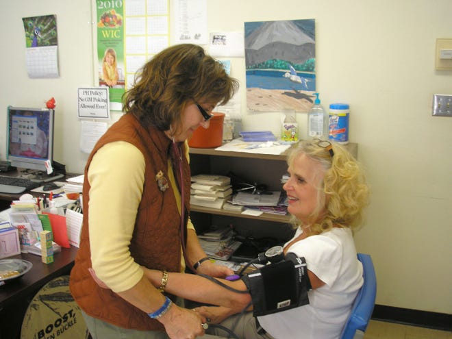 Nurse Annette Groves is shown here taking the blood pressure of Carol Moen at the Lake Region District Health office on the second floor of the Ramsey County Courthouse.