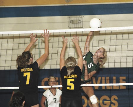 Mendon’s Jesica Doster gets a kill past Centreville blockers Kaiti Miller (7) and Breanne Rigby (5) on Wednesday.