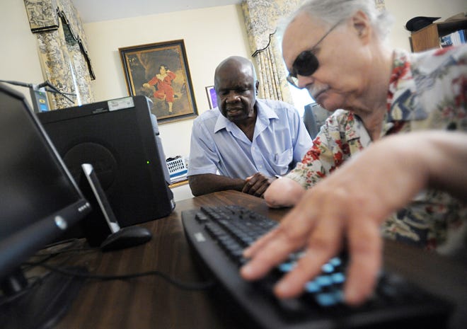 Willie Jones (left) helps Marcus Clayton with his computer skills at Clayton's Augusta home. Mr. Jones has been blind for more than 30 years and helps other visiually impaired individuals with computers.
