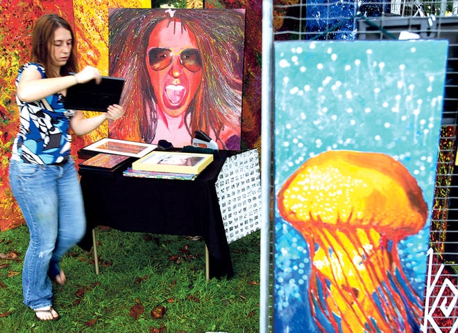 Mixed media artist Karisa Doane moves to set up her display tent Saturday morning during Art in the Park in Galesburg's Standish Park. The annual event, sponsored by the Galesburg Civic Art Center, draws artists and their works from around the area.