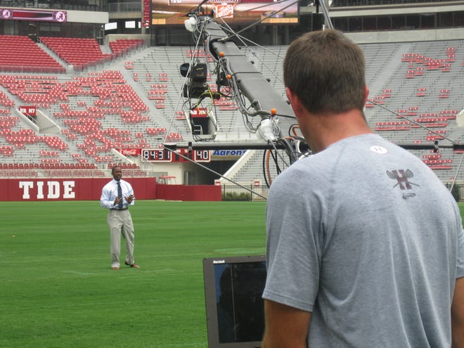 ESPN college football analyst Desmond Howard walks through a play during production of his ESPN GameDay virtual segment featuring EA Sports College Football at Bryant Denny Stadium Thursday.