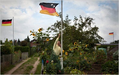 Jens John raising a variation of the German flag in his garden in Brandenburg an der Havel, Germany. A truck driver, Mr. John has often been without work in the economic downturn.