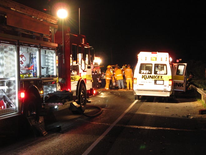 Firefighters work to free an injured driver from the wreckage of his vehicle Friday night after a two-car accident that left one dead. Sept. 10, 2010.
