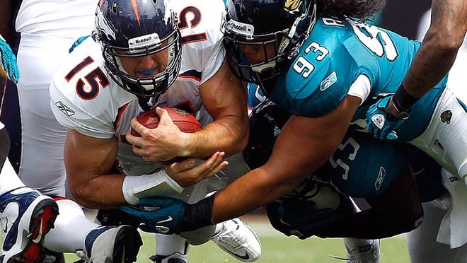 Tim Tebow, who's tackled by Jacksonville's Tyson Alualu, gains 1 yard on one of his two carries in his NFL debut on Sept. 12, 2010. The former Gators star was playing in Jacksonville, near where he grew up.