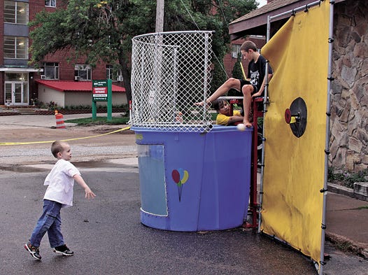 Joseph Anastasi, age 5, brings the heat with this perfect pitch — knocking Isaiah Reinke into the drink at the First Church of Christ’s annual Fall Family Fun Festival on Saturday. Other activities included a hog roast, face painting, games and music. The church is located at 300 W. Spruce St. in Sault Ste. Marie.