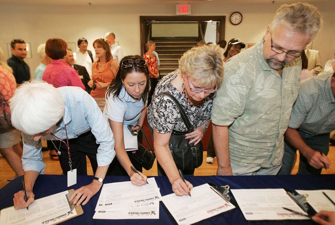 People sign petitions during a campaign meeting to bring an Embry-Riddle Aeronautical University campus to Rockford on Monday, Sept. 13, 2010, at Memorial Hal.