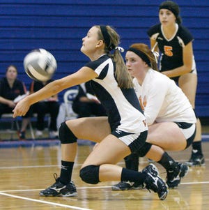 Hoover’s Lauren Brumbaugh digs out a ball as the Vikings’ Nicole Cunningham (middle) and Maggie Desrosiers follow the play during Tuesday’s Federal League match at Lake. Hoover won in three games to improve to 9-0 on the season.