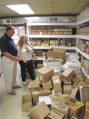 The Rev. David Kniker and Marge Davis look over the overcrowded back room at the Kewanee Food Pantry.