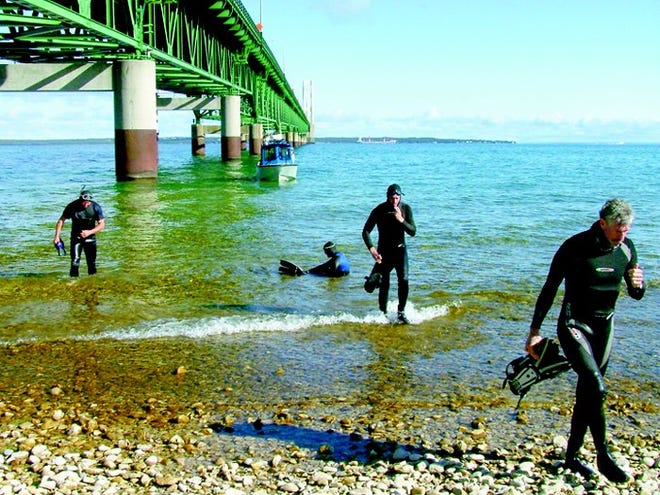 Four of the six Michigan State Police divers who swam the Straits of Mackinac Wednesday to benefit Special Olympics Michigan athletes walked ashore in Mackinaw City at the south end of the Mackinac Bridge. Troopers Austin Hessling of Caro, Dale Girke of Flint, Jennifer Hodgson of Brighton, Shawn Wise of Kalkaska, Craig Dorenbecker of St. Ignace and MSP Dive Team Captain Randy Garros of Lansing completed the five-mile swim in three hours. The Law Enforcement Torch Run also took place across the bridge Wednesday, with representatives from the MSP, Michigan Department of Corrections and local law enforcement running through Cheboygan County with special athletes. The 750-mile, non-stop relay run began at noon on Monday in Copper Harbor and ends Friday at the FOP Hall in Sterling Heights at 6 p.m.